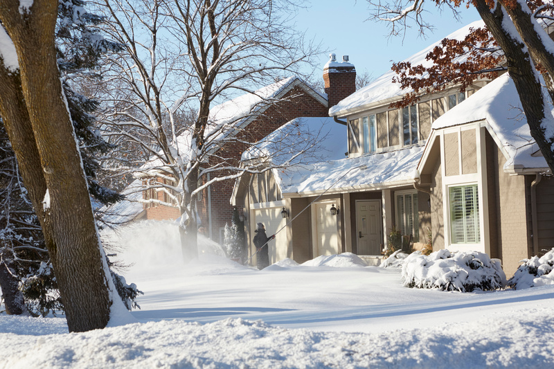 Woman Raking Her Roof From A Huge Snow Storm In The Middle Of Winter In Minnesota